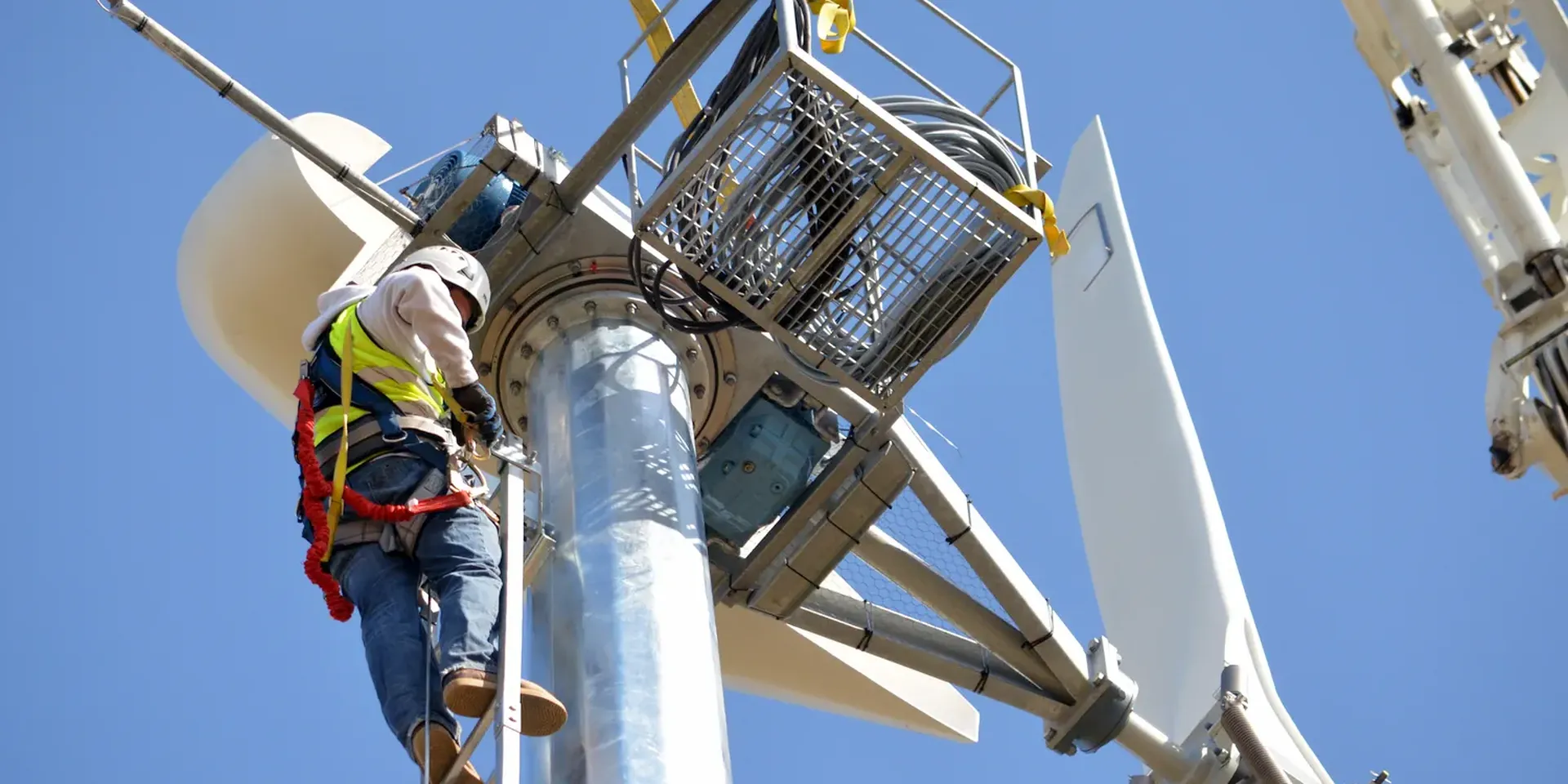 Een technicus werkt aan een windturbine