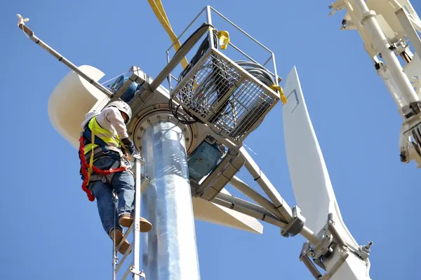 Een technicus werkt aan een windturbine
