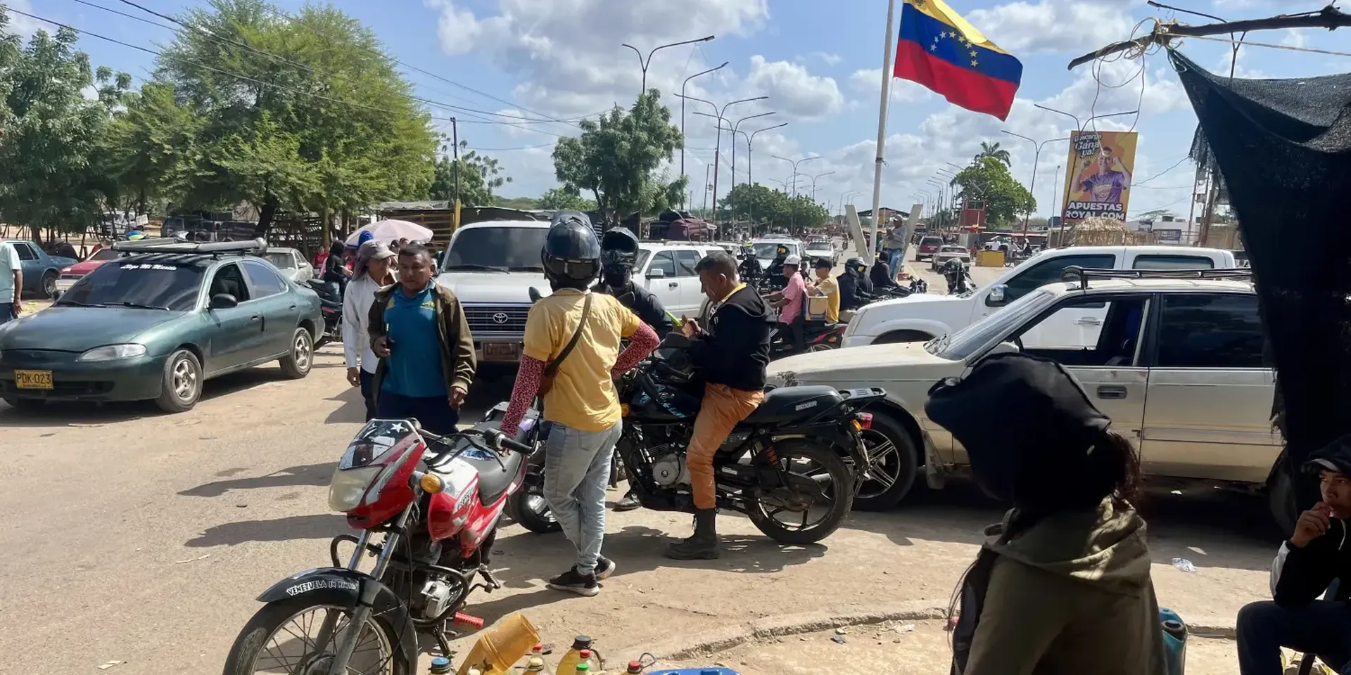 drukke grensovergang tussen Venezuela en Colombia. Op de voorgrond een informele benzineverkoopster