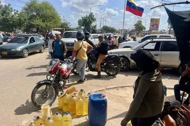 drukke grensovergang tussen Venezuela en Colombia. Op de voorgrond een informele benzineverkoopster