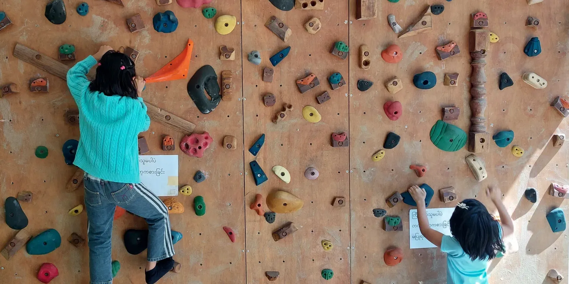 kinderen klimmen op een klimmuur