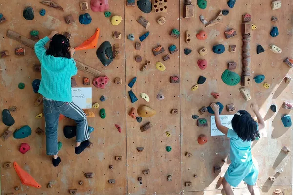 kinderen klimmen op een klimmuur
