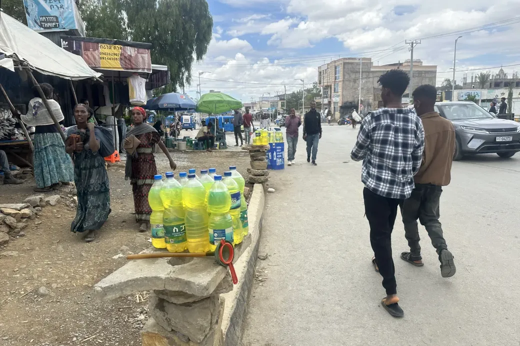Literflessen benzine aan de kant van een drukke straat