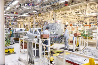 arbeiders aan een band in een aurtofabriek