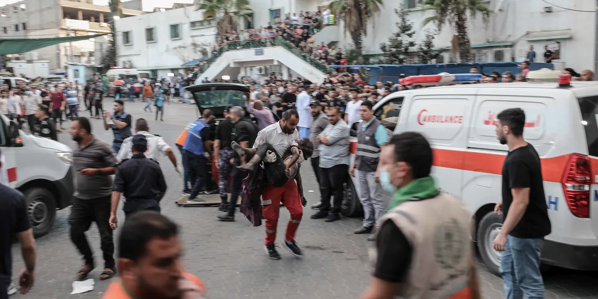 Een plein (in Gaza) vol mensen ziekenwagenen