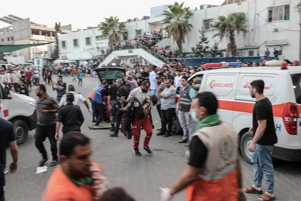 Een plein (in Gaza) vol mensen ziekenwagenen
