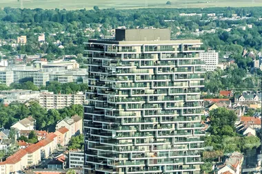 Een appartementsgebouw torent hoog uit boven de omliggende stad
