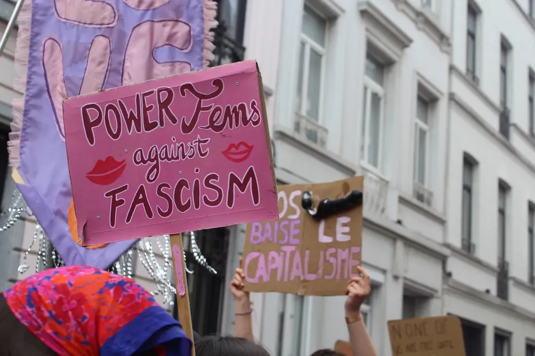 pancartes tijdens een pride mars met de tekst ‘Power Fems against Fascism’