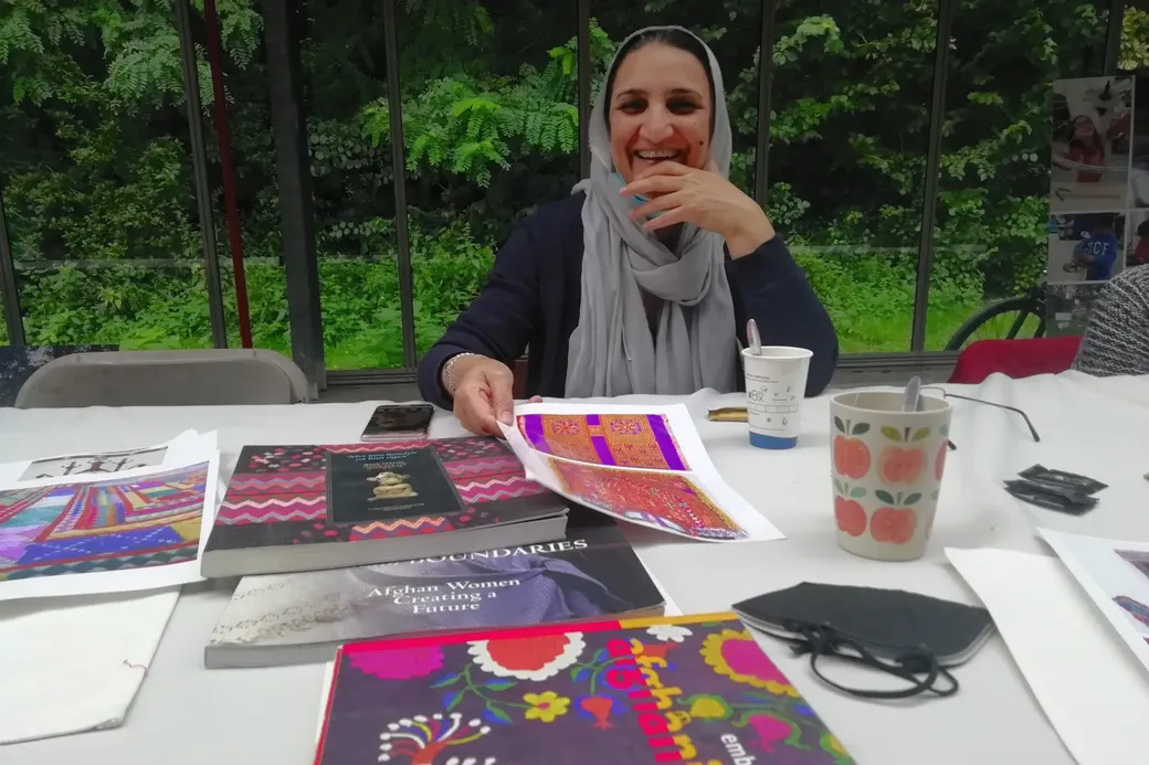 Een Afghaanse vrouw toont een borduurpatroon