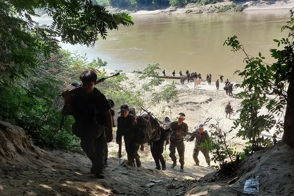 Soldaten beklimmen de steile oever van een rivier