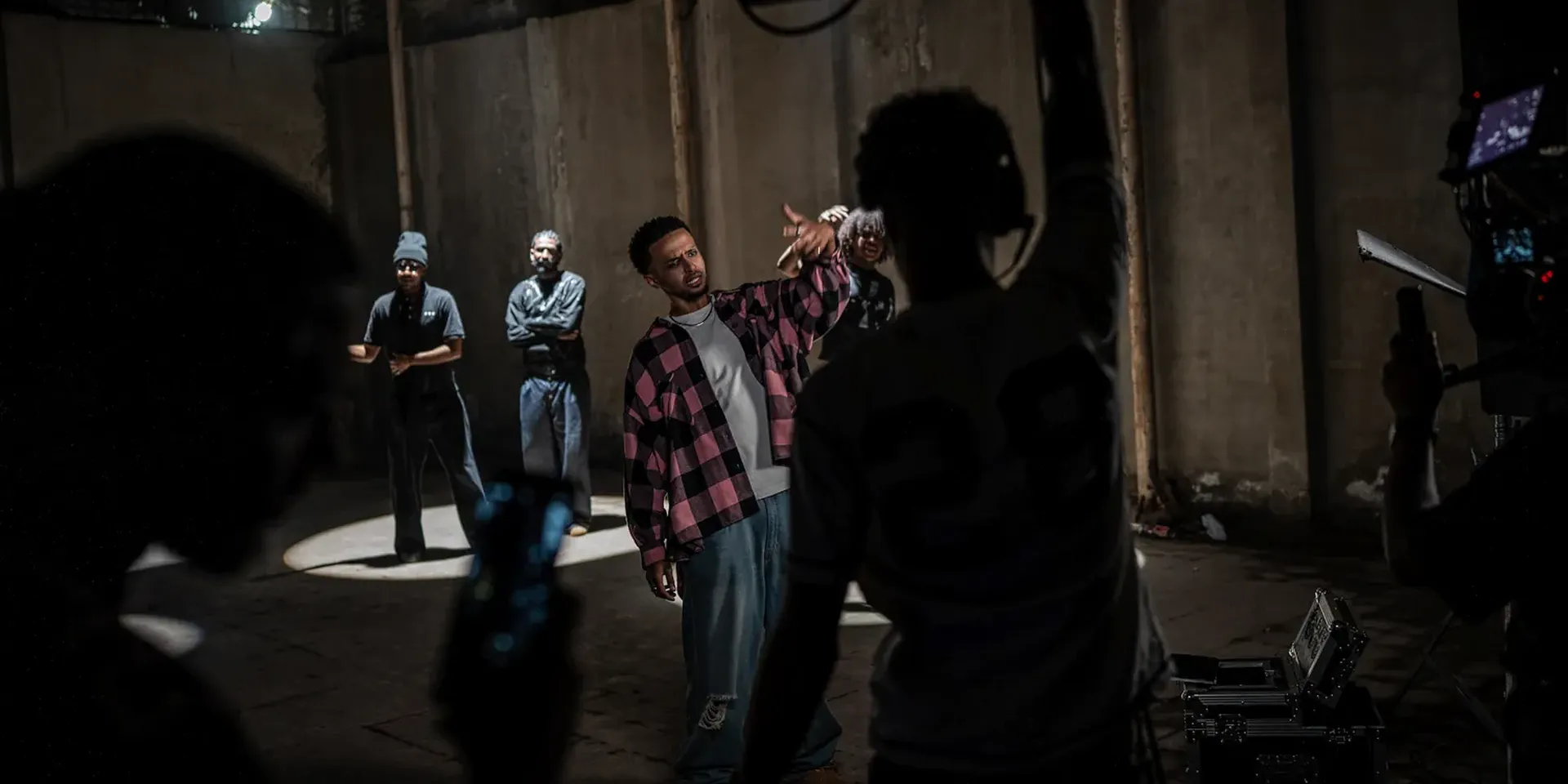 Een cameraploeg filmt een rapper in een grote afgesloten ruimte tijdens opnames voor een videoclip