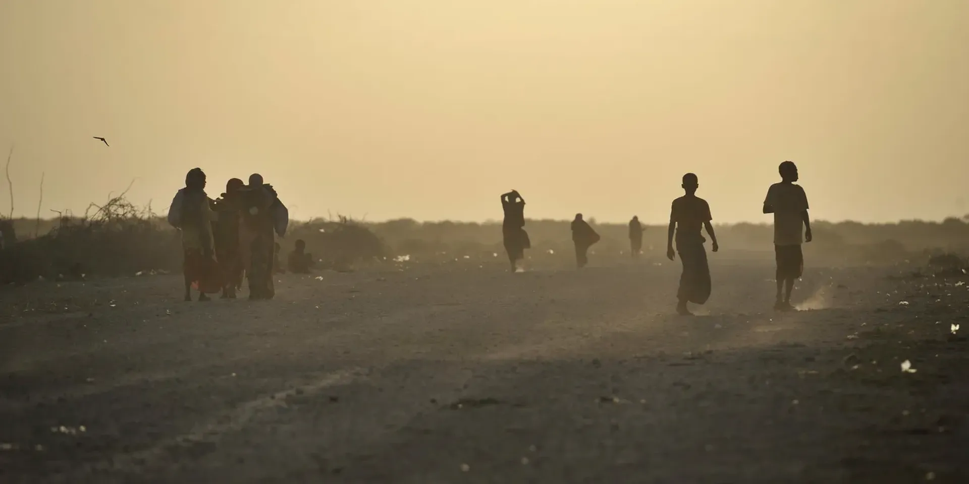 silhouetten van mensen op een stoffige weg