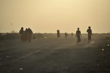 silhouetten van mensen op een stoffige weg