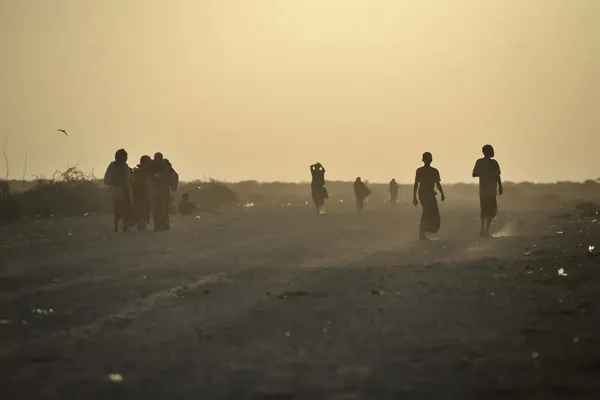 silhouetten van mensen op een stoffige weg