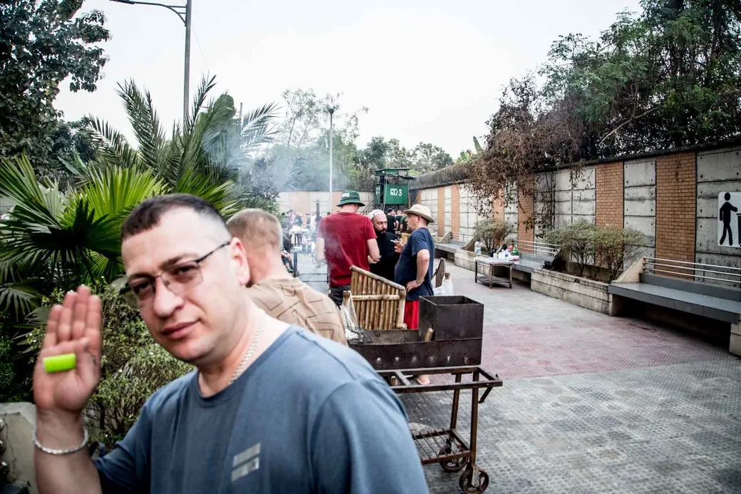Arbeider Sasha Yevgenyev begroet ons bij de barbecue. Op de achtergrond zie je een uitkijkpost van het Bengaalse leger.