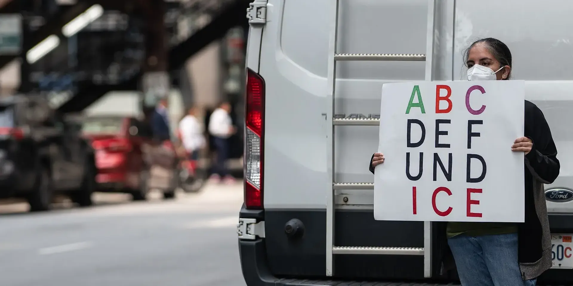 vrouw met een pancarte waarop staat: ABC DEF UND ICE