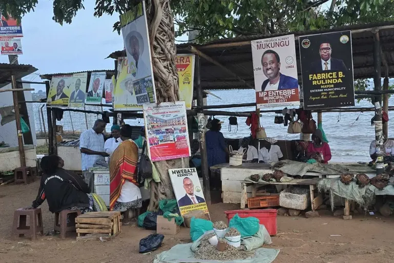 Verkiezingsplakkaten aan een standje aan de oever van een meer