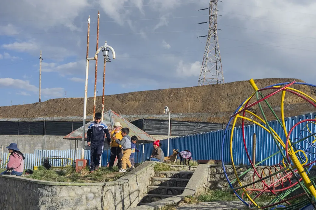 kinderen spelen op een pleintje naast mijnafvalhopen