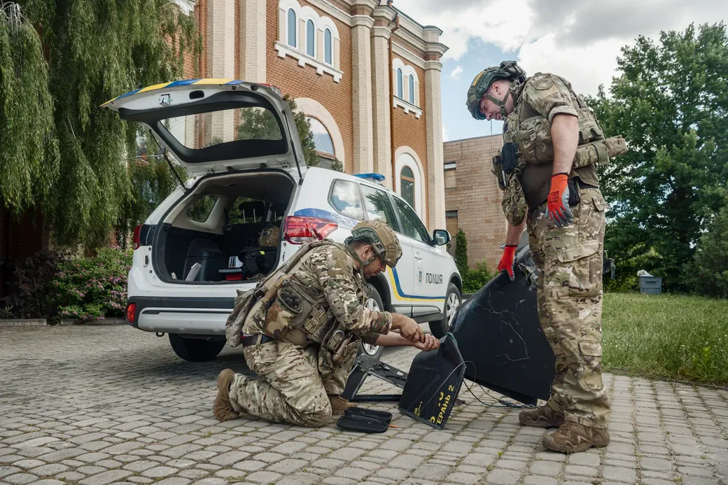 Oekraïense militairen demonteren een ingeslagen drone in Charkiv.