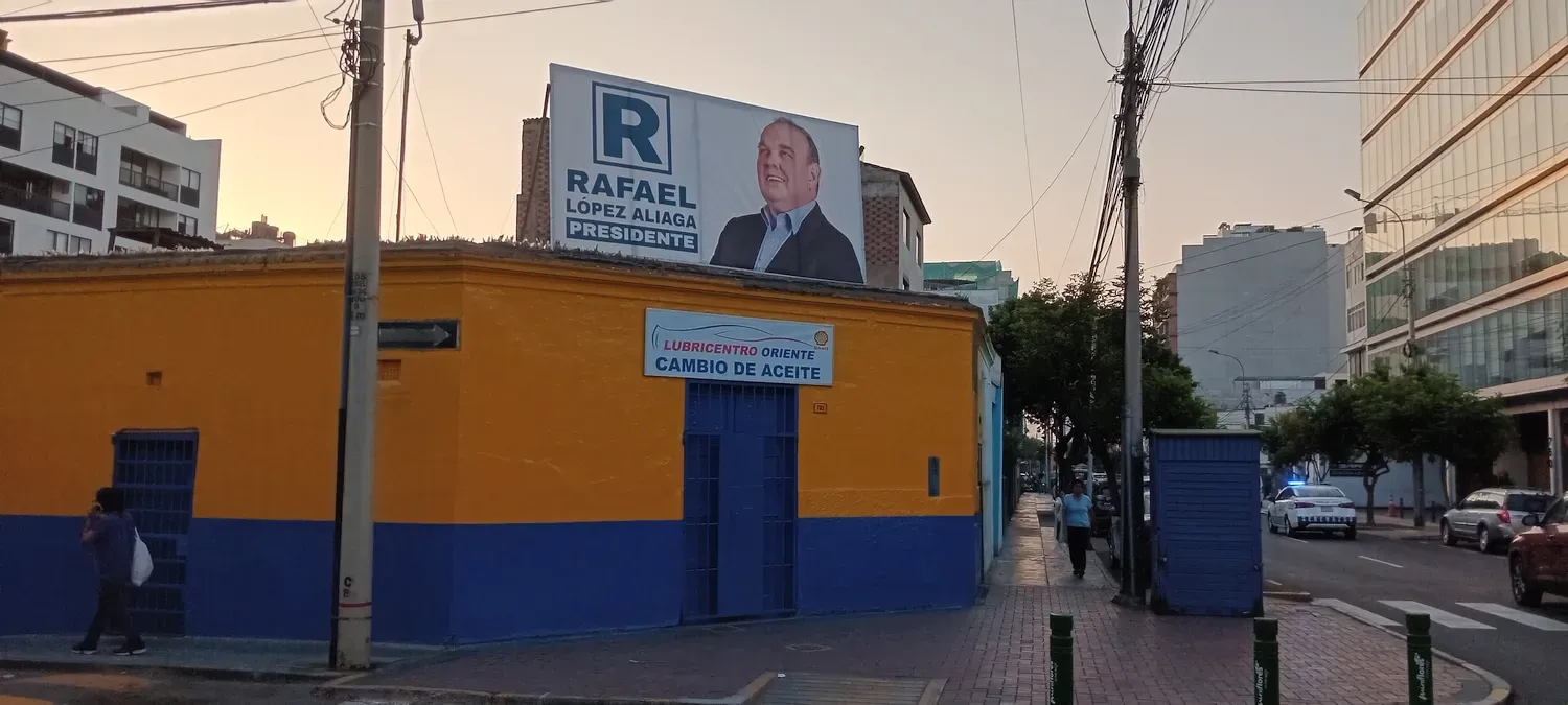 Een Campagneposter van Lopez Aliaga bovenop een muur