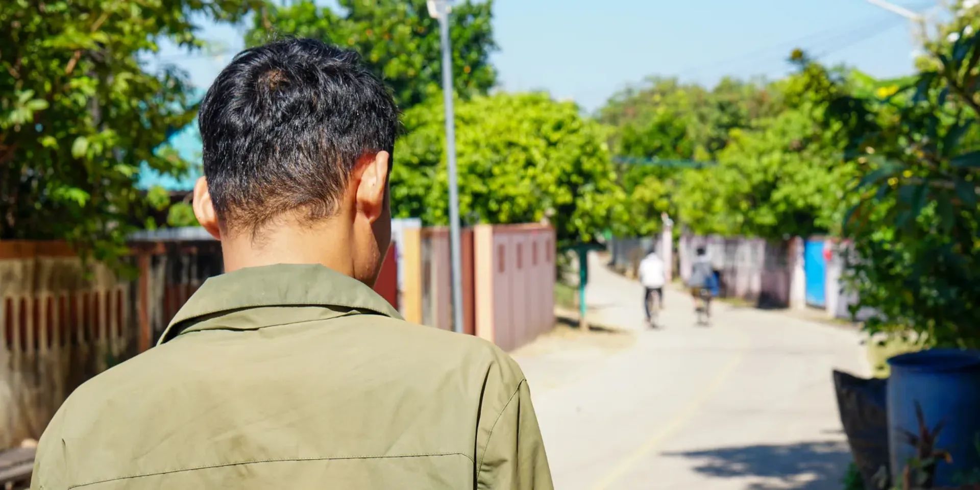 Een Birmese ex-scammer staat met zijn rug naar de camera