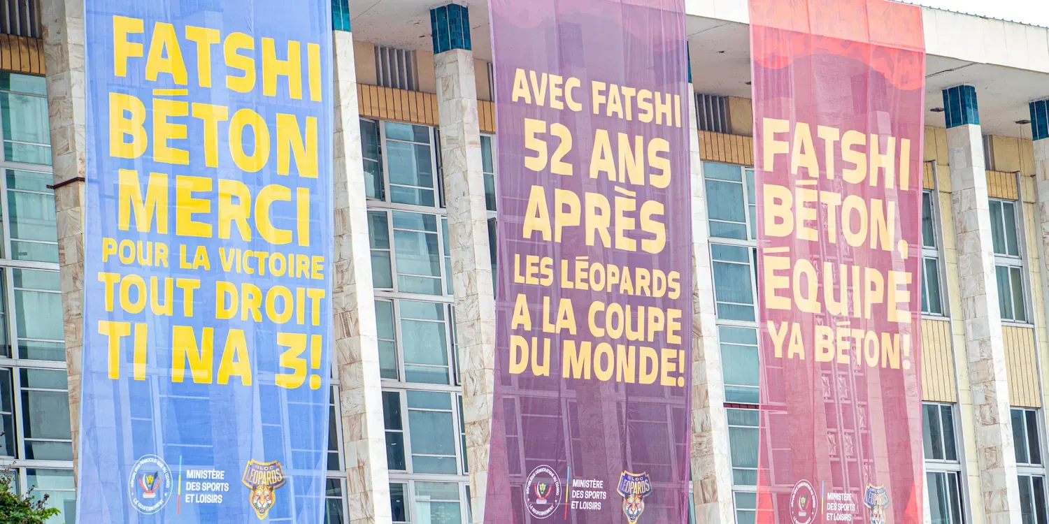 Bannieren met de tekst “Fatshi Béton merci pour la victoire. Tout droit Ti Na 3!