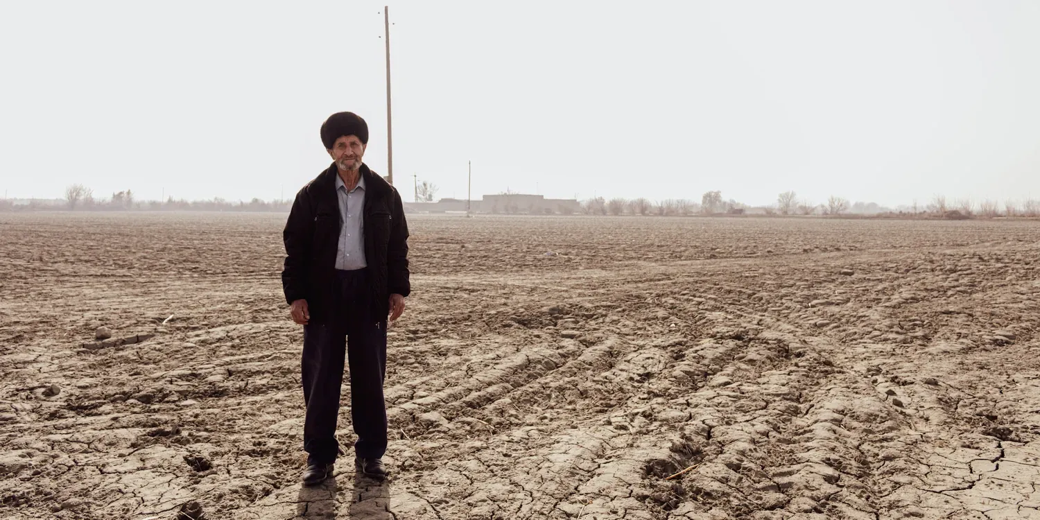 De 66-jarige landbouwer Gailbullo poseert voor de foto op zijn omgeploegde akkers