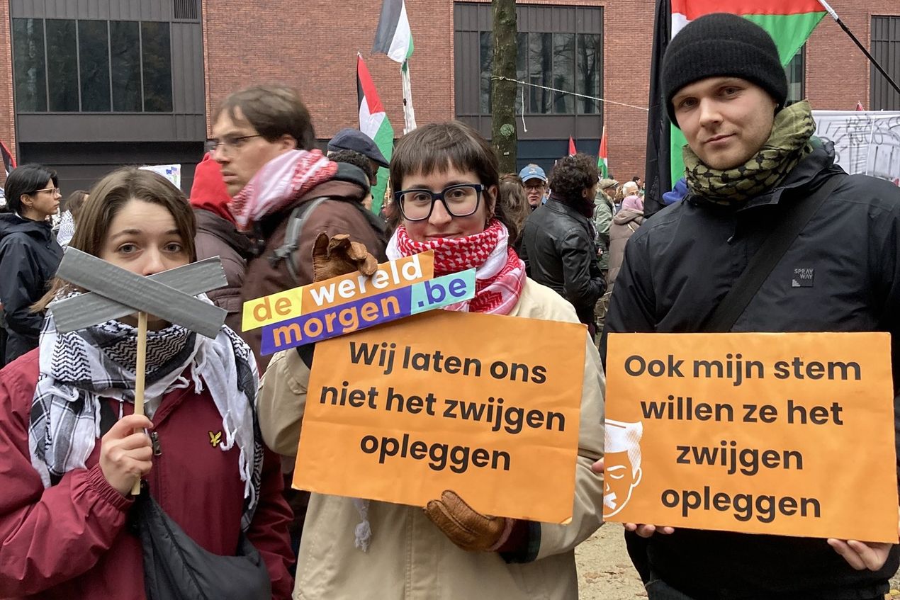 Betogers in Brussel in november dragen een logo van De Wereld Morgen en bordjes met slogans: 'Wij laten ons niet het zwijgen opleggen' en 'Oo mijn stem willen ze het zwijgen opleggen'.