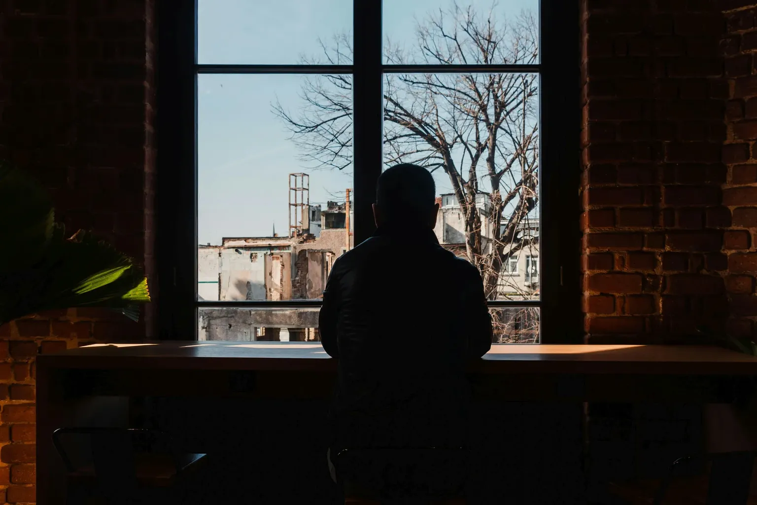 silhouet van een man die door een raam kijkt