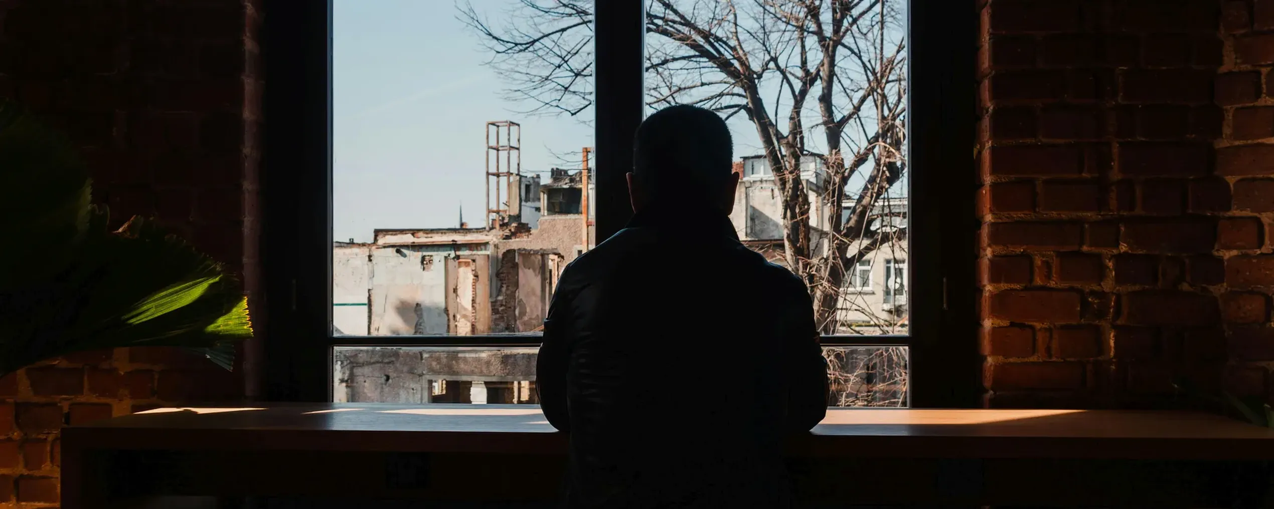 silhouet van een man die door een raam kijkt
