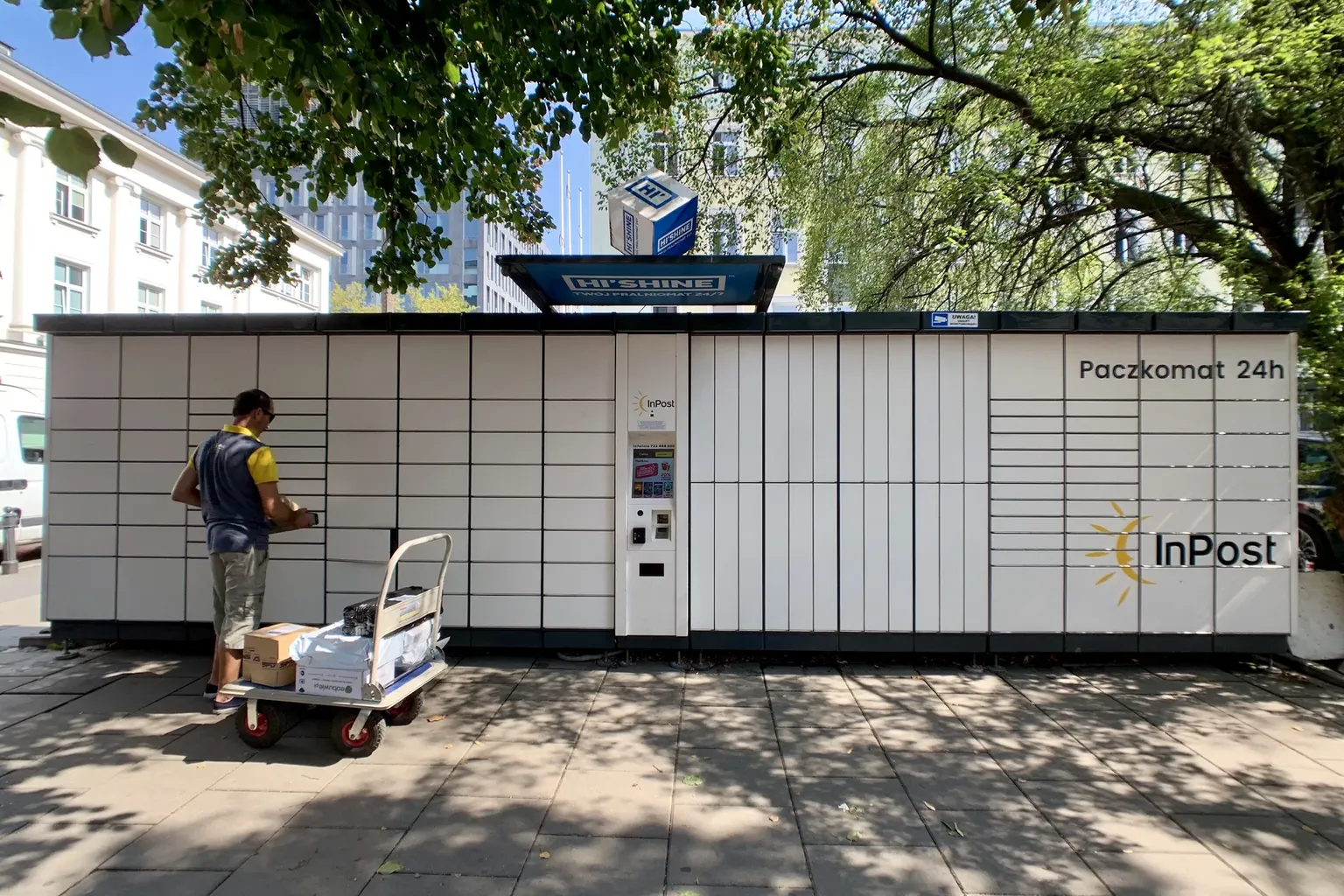 Een pakjesleverancier staat voor een typische Pacskomat, een pakketautomaat