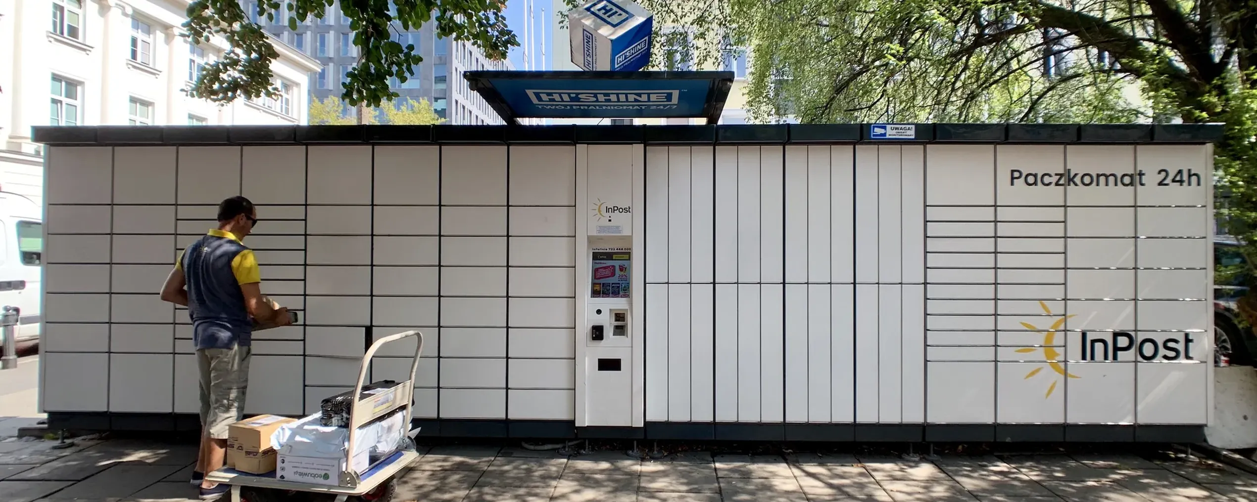 Een pakjesleverancier staat voor een typische Pacskomat, een pakketautomaat
