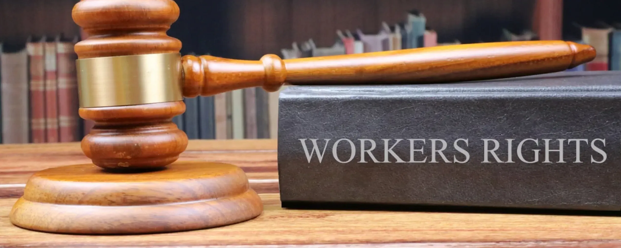 Een moker en een boek getiteld 'workers rights'