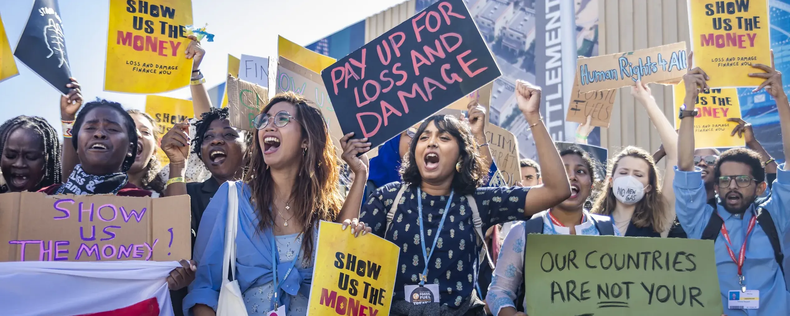 Betogende jongeren met pancartes waarop onder andere staat: ‘Show us the money’