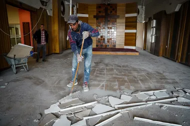 Arbeiders ruimen het puin op van een woongebouw dat werd getroffen door een droneaanval in Ankawa, een stad met een christelijke meerderheid, ten noordwesten van Erbil.