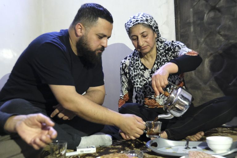 Een vrouw schenkt thee in bij een man
