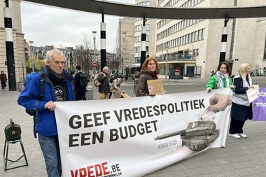 Een spandoek tijdens een actie in Brussel met de tekst 'Geef vredespolitiek een budget'