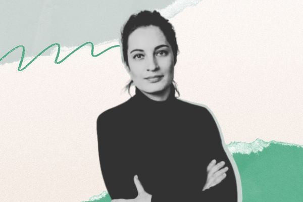 Woman in a black turtleneck with arms crossed, set against a pastel abstract background with green and gray brushstrokes and a beige backdrop.