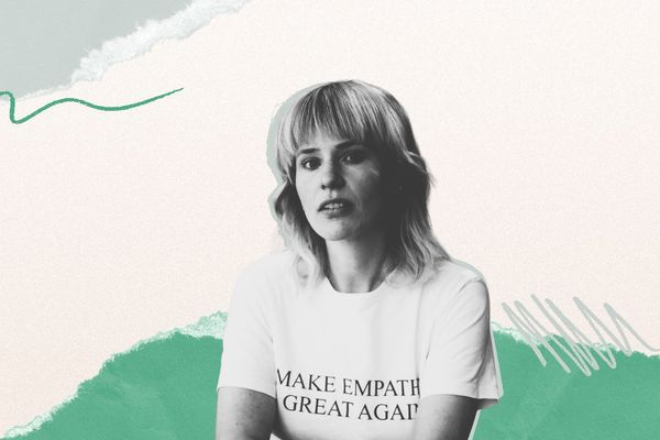 A woman with medium-length hair and bangs wears a t-shirt with "MAKE EMPATHY GREAT AGAIN" text, set against a textured green and beige background.
