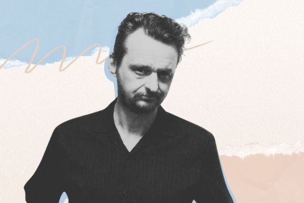 A person in black clothing stands against an abstract background with blue, peach, and white brushstrokes.