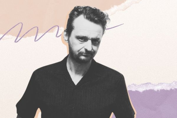 Man in a black shirt with a neutral expression stands against an abstract pastel background with scribbles and torn paper textures.