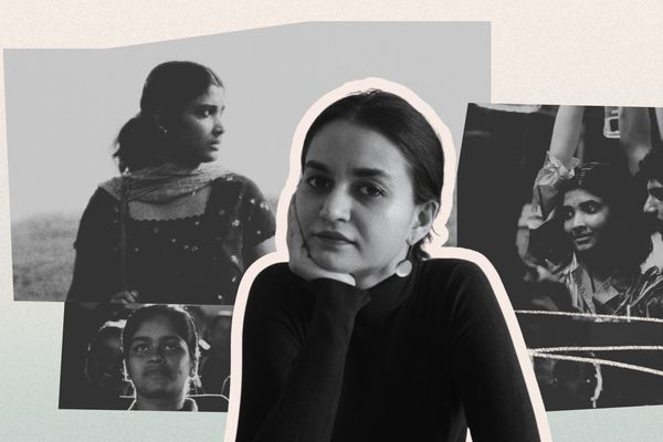 A woman in a black top poses with her hand on her chin, with black and white photos of people in the background.