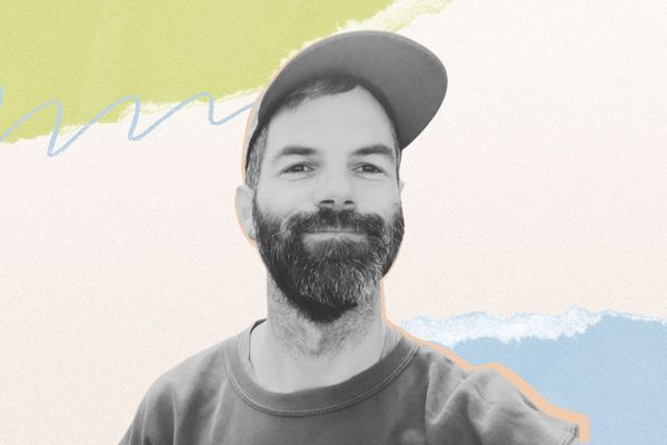 Smiling man with a beard and cap against a colorful, abstract background of pastel shapes.