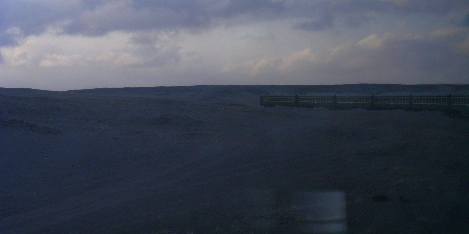 een trein rijdt door een schemerig landschap