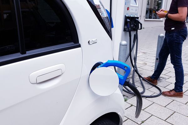 close up van een elektrische lader aan een wagen.