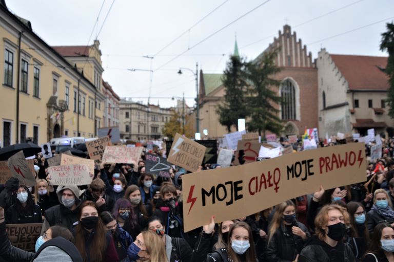 Demonstranten houden borden omhoog in een straat in Krakau, waaronder één met de tekst “Moje ciało, moje prawo” (“Mijn lichaam, mijn keuze”), tijdens protesten voor vrouwenrechten in oktober 2020.