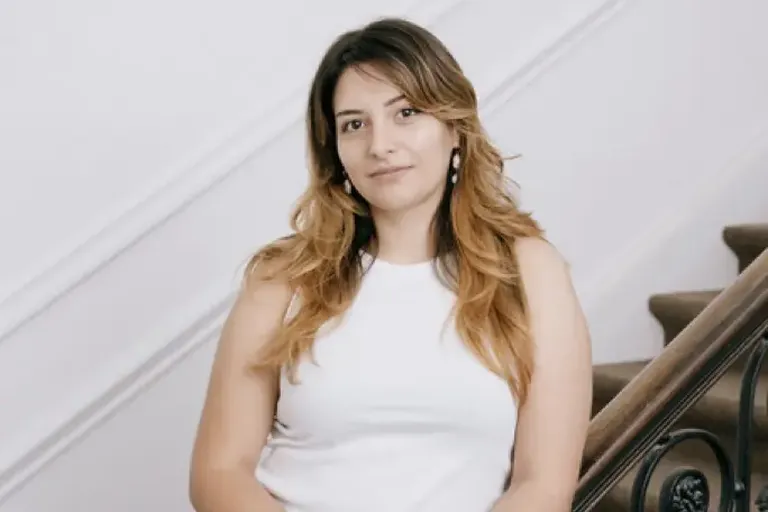 Portretfoto van Paola Verhaert, staand aan een trap