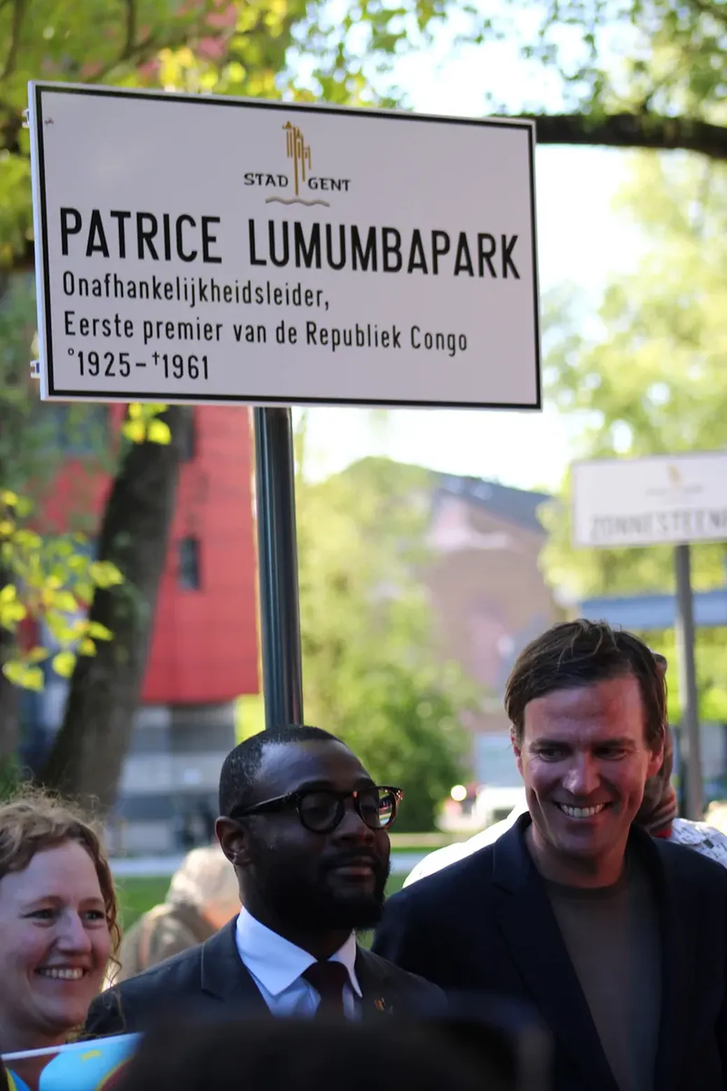 De vertegenwoordiger van de Congolese consul, Ephraim Kalonji staat samen met burgemeestger van Gent Mathias De Clercq voor het kersverse naambord van het Patrice Lumumbapark