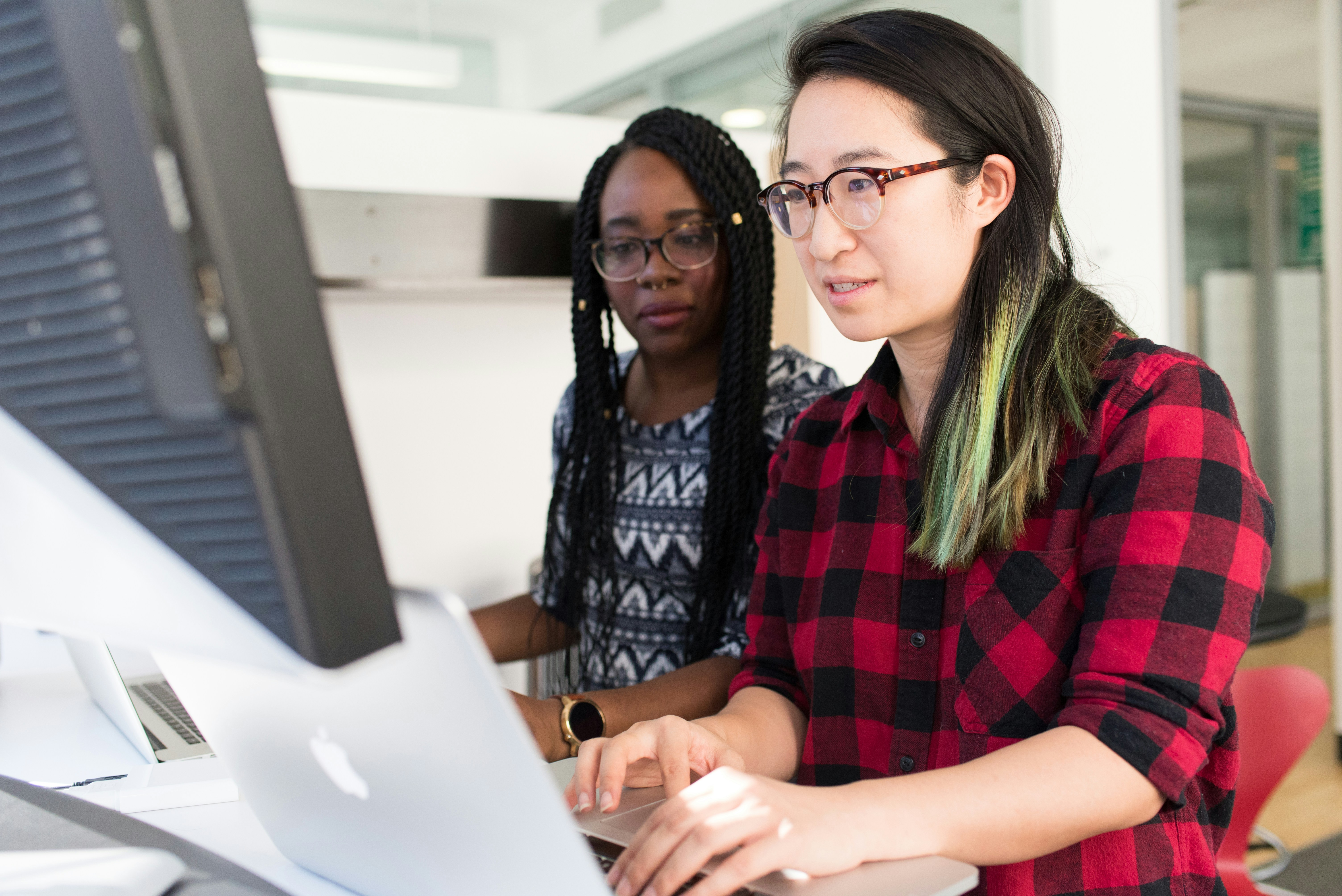 Two women working at computers in an office