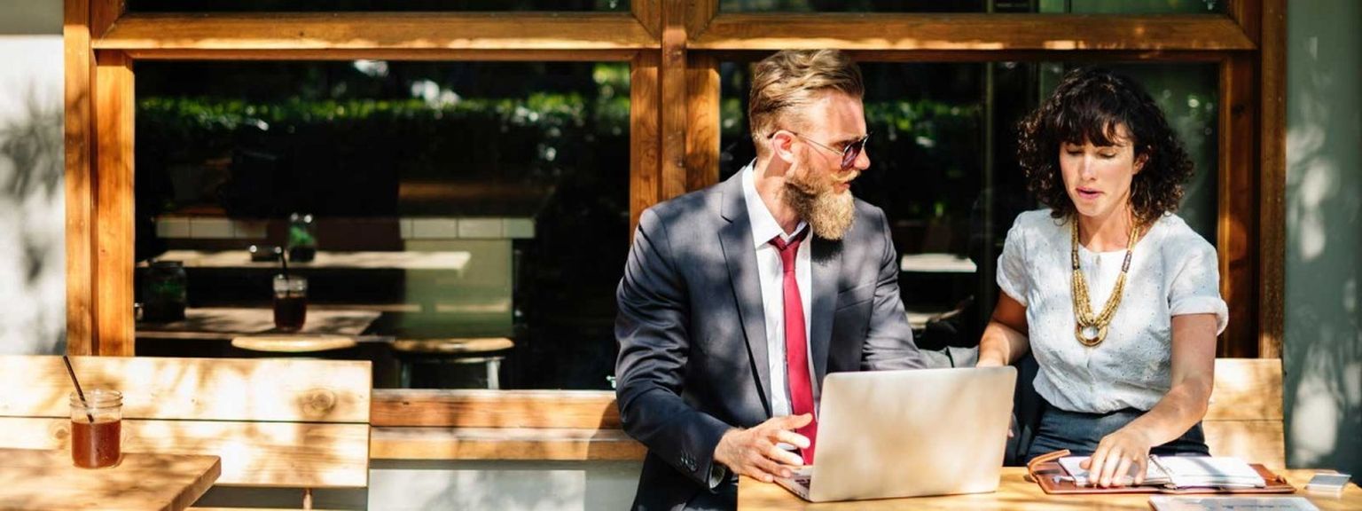 A financial adviser gives advice to a young professional woman